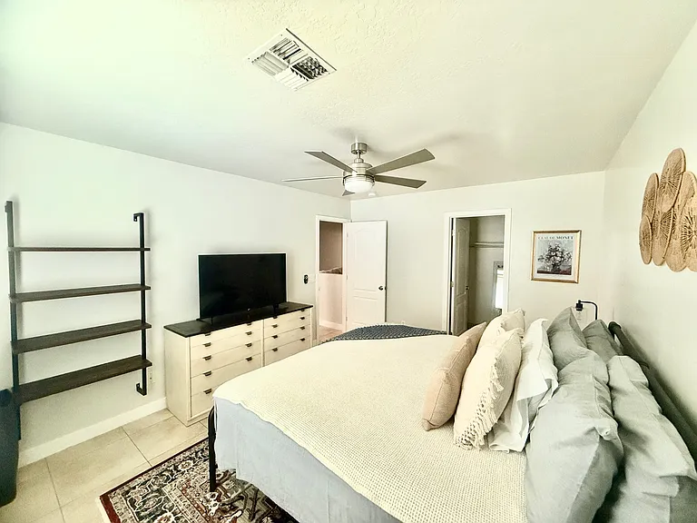 King Bedroom 1 with dresser, TV, walk in closet, shelving