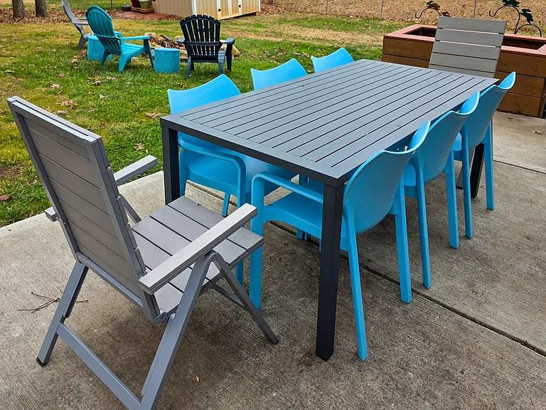 The dining area overlooks the large fully-fenced yard, fire pit, and raised planter bed that's ready for flowers or vegetables.