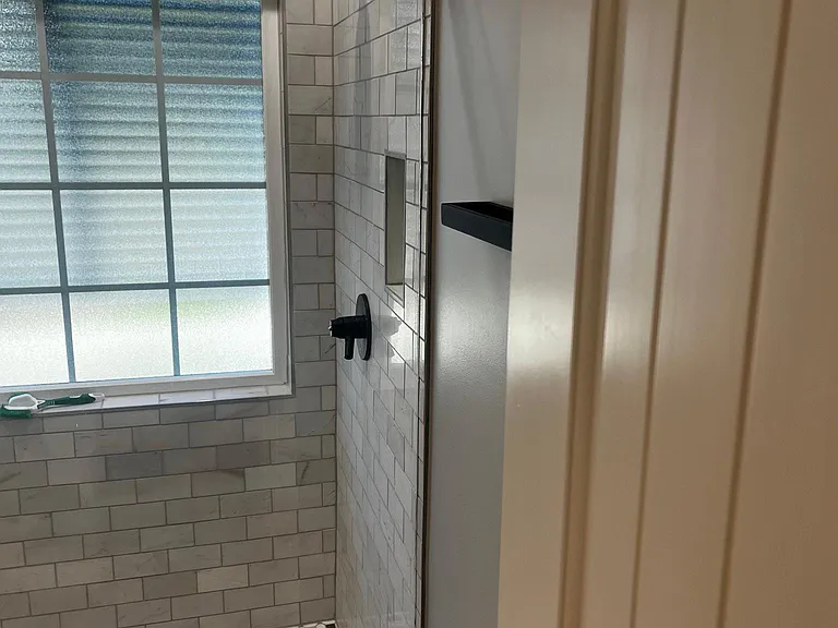 Primary bathroom walk-in shower with modern black fixtures and beautiful tile.