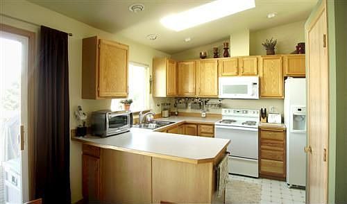 Kitchen is open to dining room with an eating bar peninsula