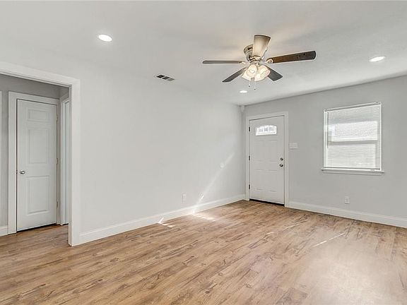 Entry into bright living room, with recessed lighting and ceiling fan.