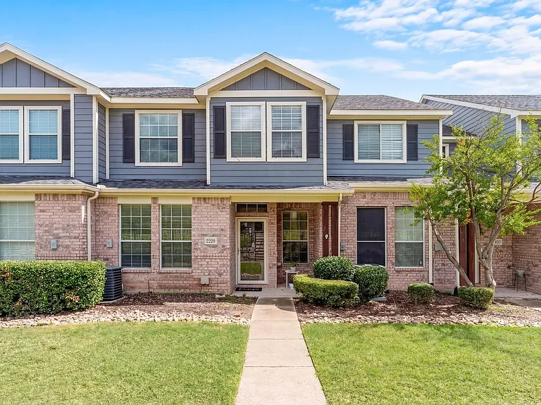 Front Entry with large common lawn. Glass door. Window above one of 3 bedrooms.