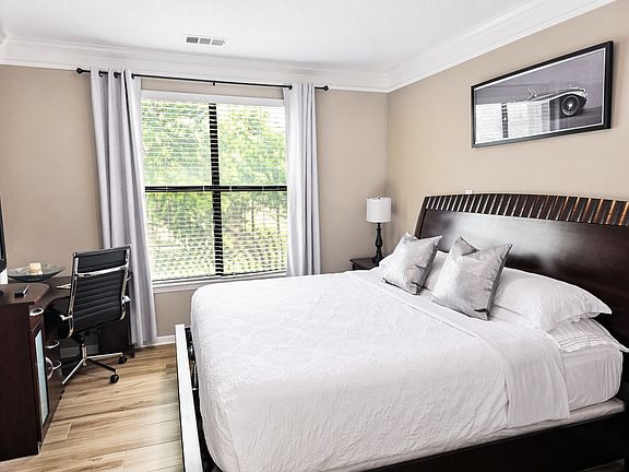 Relax in a spacious bedroom with a king-size bed, walk-in closet, flat-screen TV, and a functional workspace_ideal for remote work or study.
