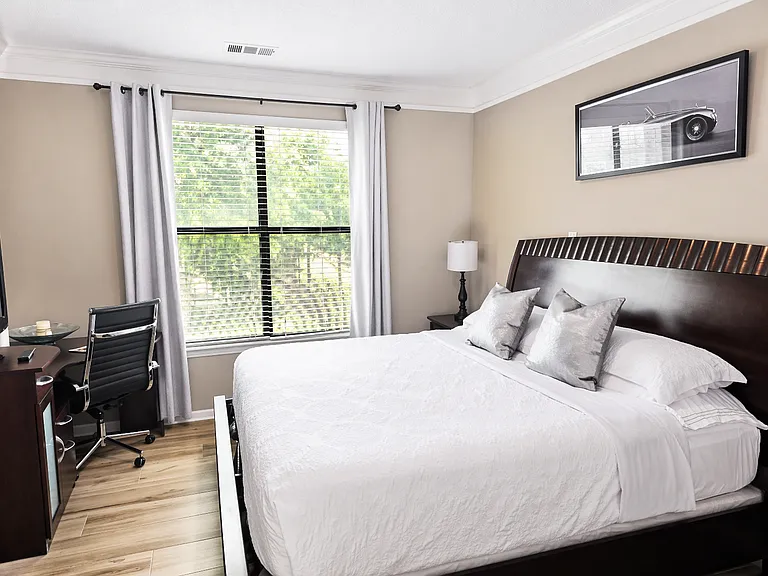 Relax in a spacious bedroom with a king-size bed, walk-in closet, flat-screen TV, and a functional workspace_ideal for remote work or study.