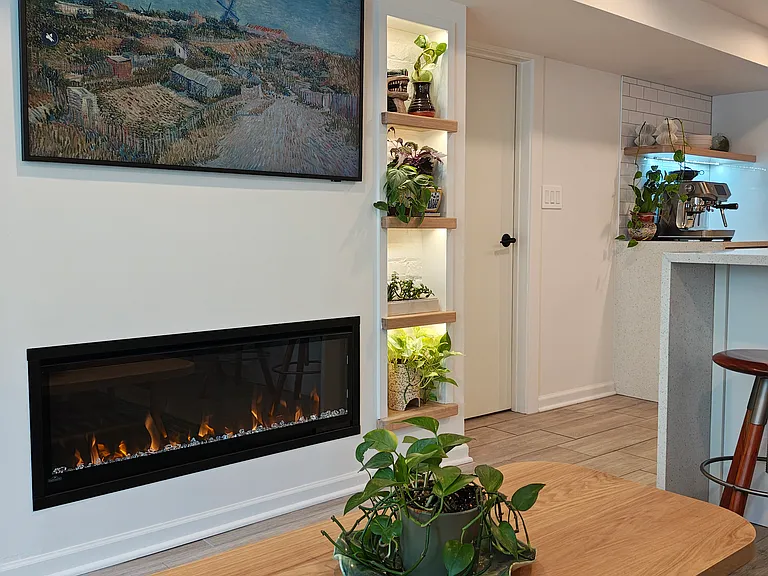 TV, electric fireplace, and built-in shelves that light up.