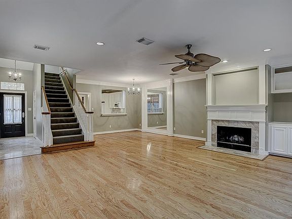 View showing marble entry/foyer, powder room is out of sight to the right here; staircase has white-painted balusters & wood hand railing; cozy Dining Room with amazing wood framed mirror, pass thru and doorway to Kitchen/Breakfast area.