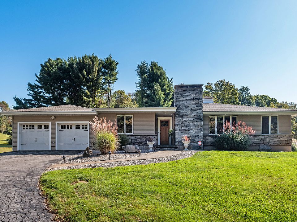 Front view of home, perfectly situated, with a manicured lawn, an elegant walkway and nicely landscaped beds.
