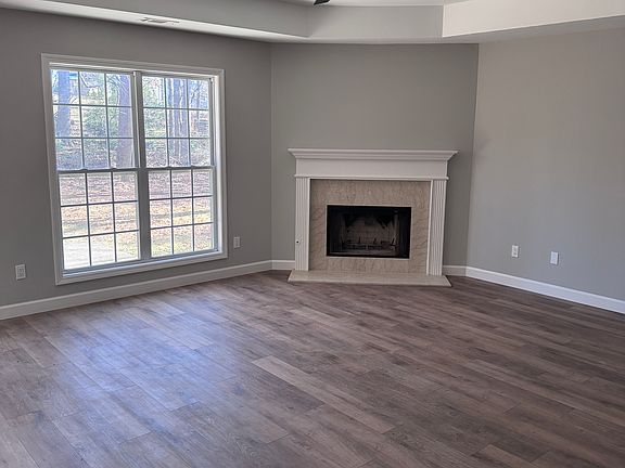 Spacious living room off back of house with functioning gas fireplace.