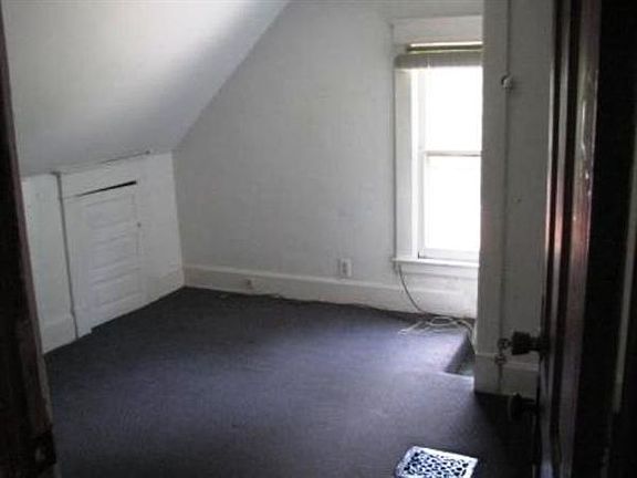 This is a cozy bedroom with ample natural light and lots of