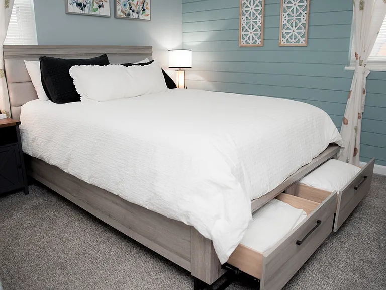 A serene space featuring soft blue tones, delicate floral art, and a plush, comfortable bed.