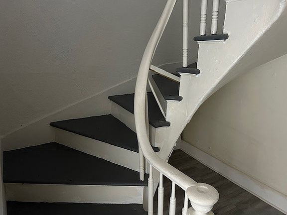 Winding stairs lead to second level where two bedrooms are and full bath.