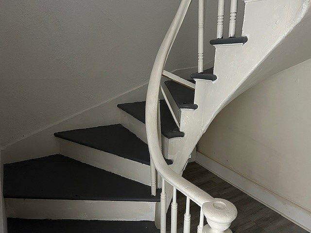 Winding stairs lead to second level where two bedrooms are and full bath.
