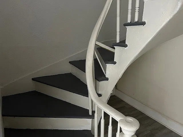 Winding stairs lead to second level where two bedrooms are and full bath.