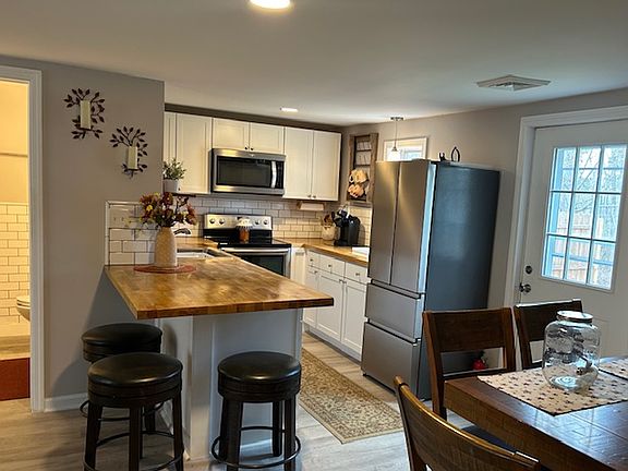 View from bedroom, dining room bartop and access to backyard space with privacy fence.
