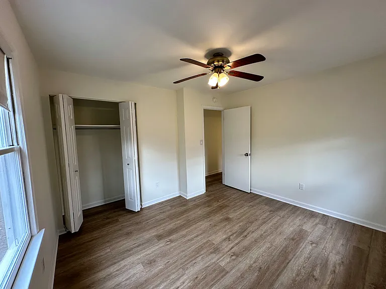 Additional photo of the Bedroom #3 with a view of the side yard and backyard, features a larger closet. This bedroom is located at the end of the hallway and shares a wall with the large bathroom.