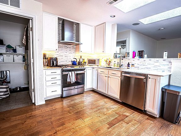 Quartz countertops and backsplash, gas five-burner cooktop, large stainless steel kitchen sink with ample storage and huge pantry with racking.