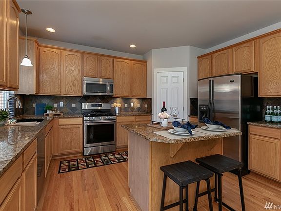 Kitchen is gorgeous with hardwood floors, granite counter tops, slate tile back-splash, loads of cabinets, stainless appliances, island with breakfast bar and a large pantry for all your storage needs. 