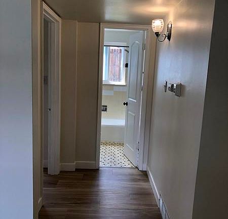 Hallway to bathroom and bedroom. Thermostat is programmable for heat.