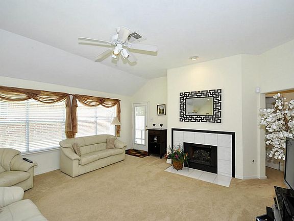 Spacious den has a vaulted ceiling. A wall of windows make the space light and bright.