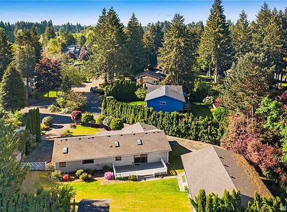 Rear view of home.  Nice trex deck, private rear yard and driveway with gate for shop access.
