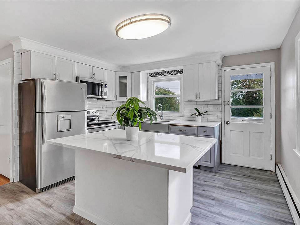 Beautifully renovated kitchen with island and quartz counter