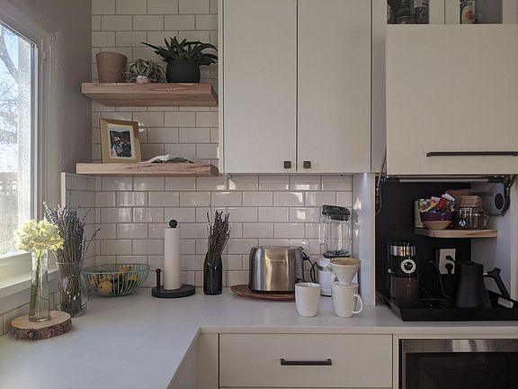 A mix of open shelving and soft-close cabinets throughout the kitchen add to the modern look.