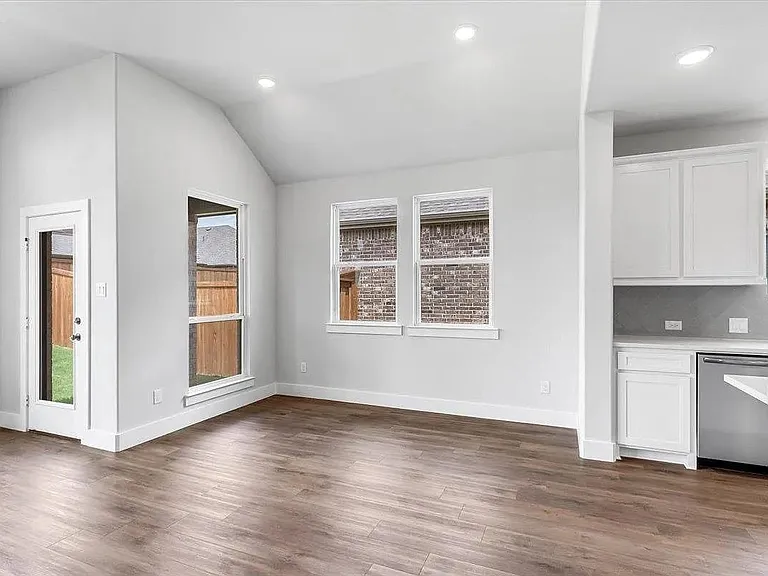 Open-concept living area featuring wood-finish flooring, recessed lighting, and a vaulted ceiling