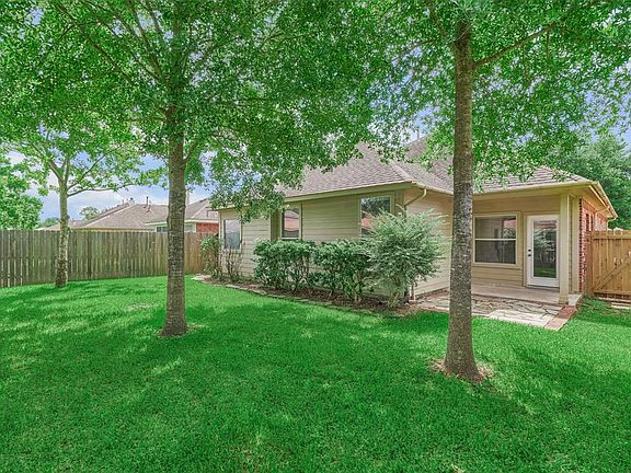 The back yard is shaded with a covered porch.
