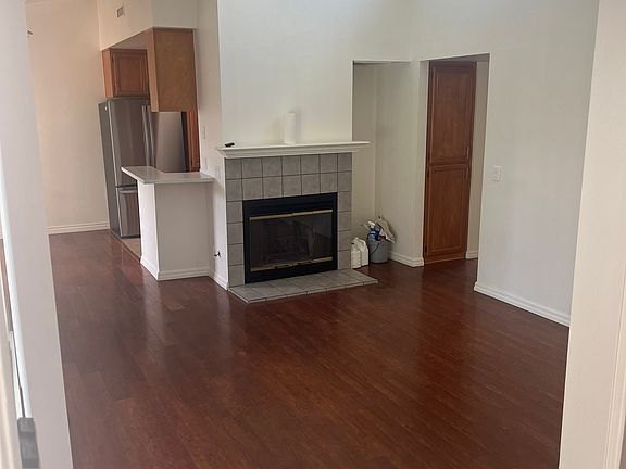 Front door view of unit. Showing main living space, with dining nook and kithen to the left and storage hallways access to the bedrooms on the right.
