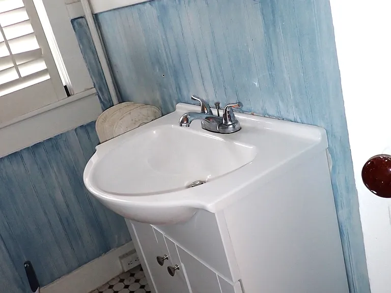beautiful antique mosaic tiles on floor. there is a large built in storage shelving, beautiful tiled walk in shower