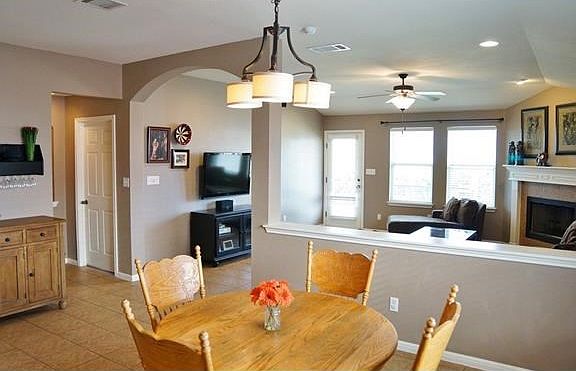 Great arch transition from the breakfast area to the living room with recessed lighting and a fireplace!