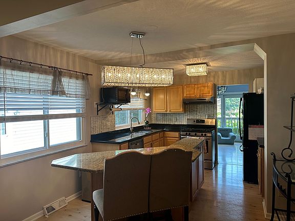 Modern Kitchen: The updated kitchen features stainless steel appliances, granite countertops, a prep sink and ample cabinetry. Cooking will be a pleasure in this well-designed space!