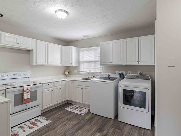a white kitchen with white appliances and white cabinets
