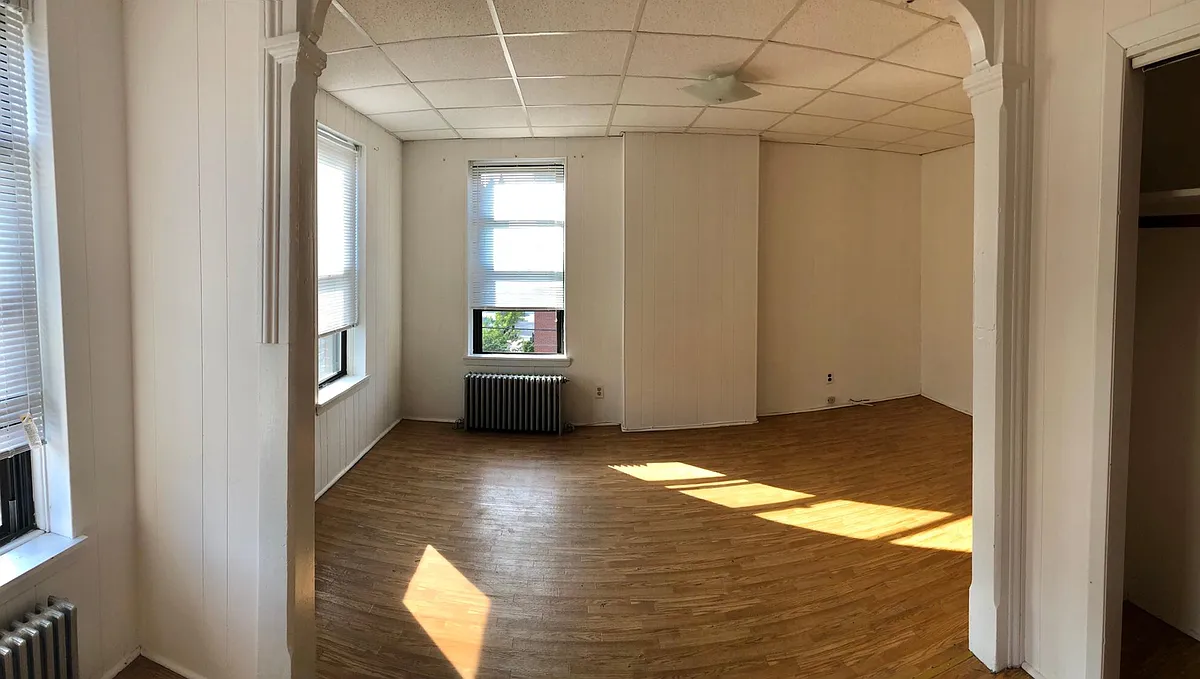 Large Bedroom divided in 2 sections like an L shape with brick exposed. - 320 Communipaw Ave #TOP FLOOR