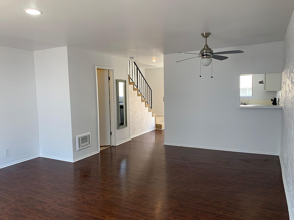 Spacious living room with wooden floors and ceiling fan