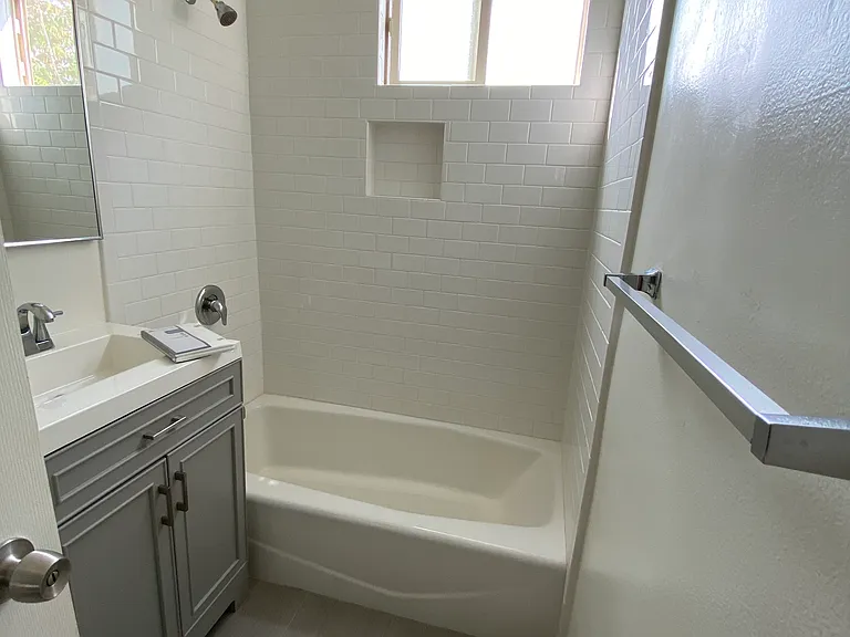Bathroom with gray vanity that matches kitchen cabinetry