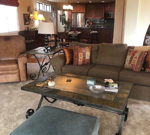 Furnished living room with couch, chairs, coffee tables, TV and more.
