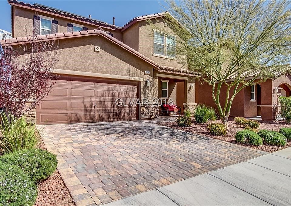 Driveway with pavers and stacked stone accents make this house pop!