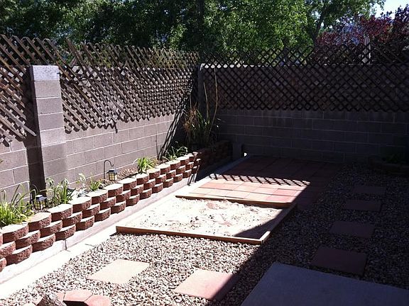 Patio with raised planter of cane, pad for grill chairs
