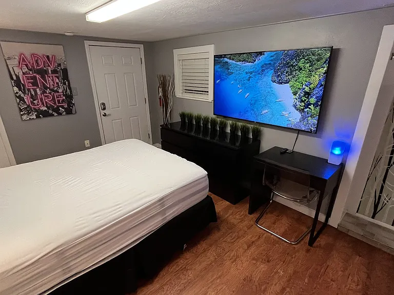 Queen bed, dual night stands with lamps, dresser, desk and chair, 65in Smart TV, full kitchen, bath.
