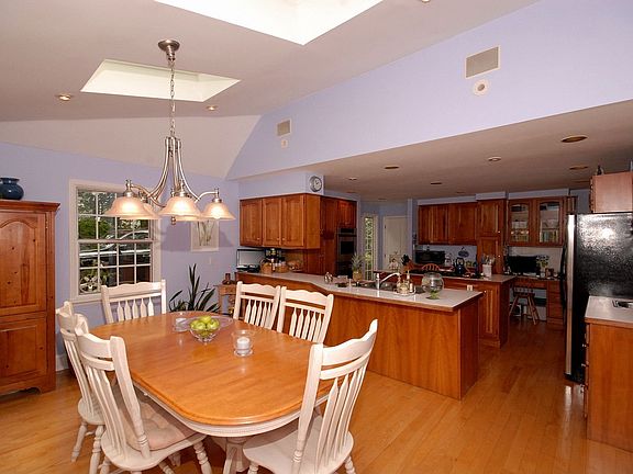 Eat-in Kitchen w/ cherry cabinetry, wet bar, stainless appliances & desk area.