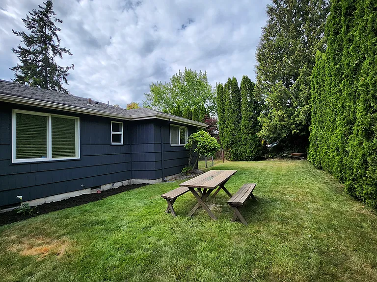 Large and private front yard with arborvitae wall.
