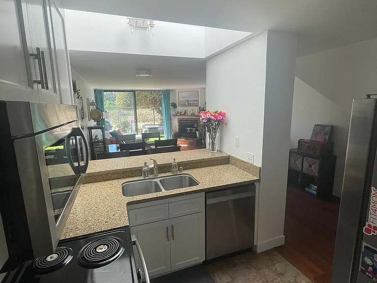 Kitchen with skylight over bar top, opens to dining and living area