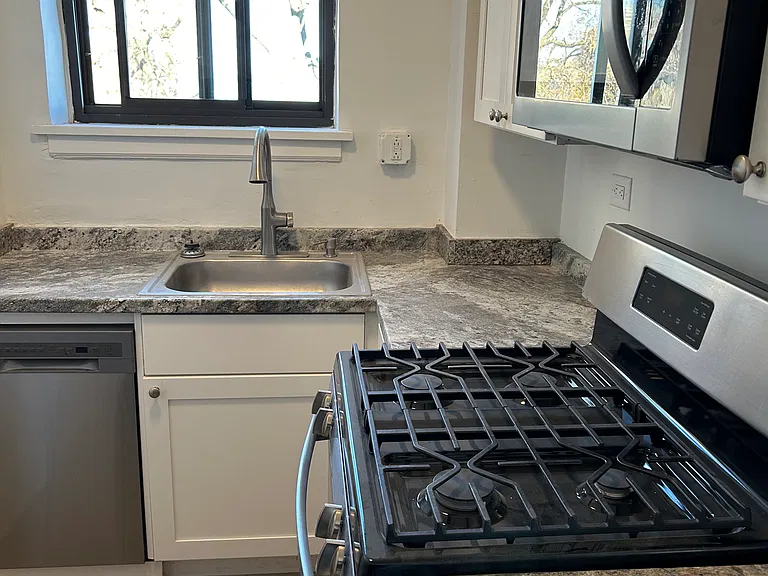 Longer view of kitchen showing small dishwasher.