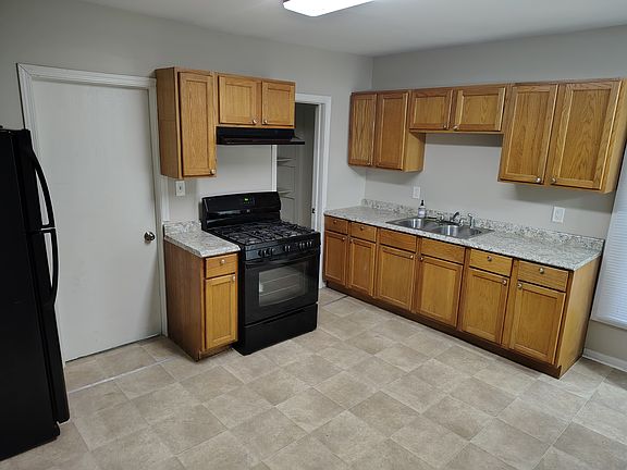 Eat-in kitchen with refrigerator, stove and pantry.