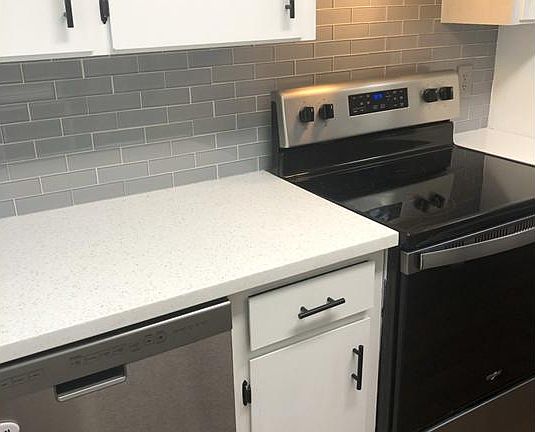 Quartz countertops with glass tile backsplash