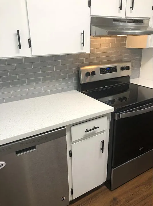 Quartz countertops with glass tile backsplash