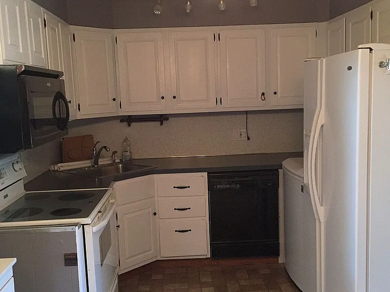 Photo of the kitchen before the laundry unit was installed. The refrigerator is now moved and built-in laundry is placed instead (see other images).