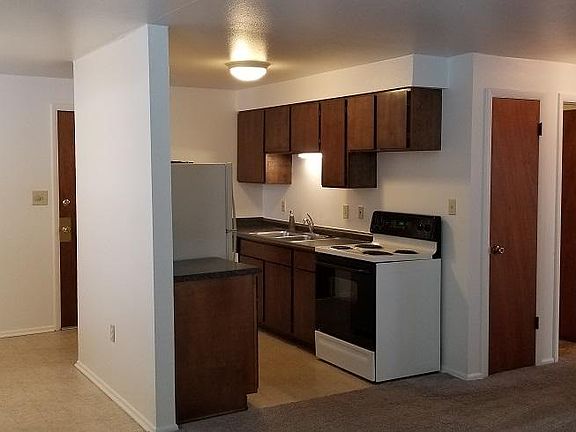 Kitchen and dining area from living. Door to garage at back of kitchen, coat closet and door to bath on right