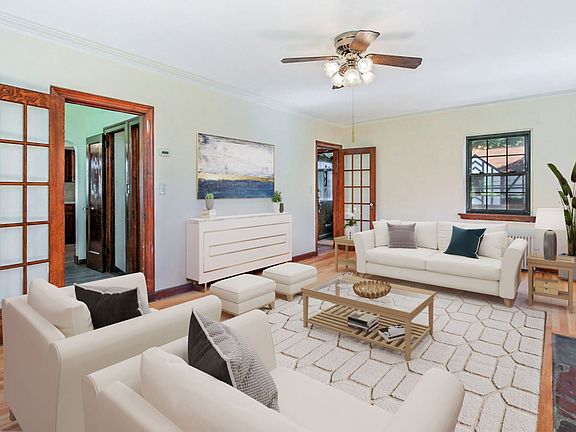Virtually staged living room w/ entrance to dining nook and foyer